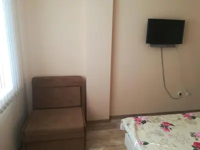 a bedroom with a bed and a tv on the wall at Apartment Batoevi Sozopol in Sozopol