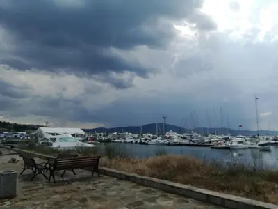 a couple of benches next to a marina with boats at Apartment Batoevi Sozopol in Sozopol