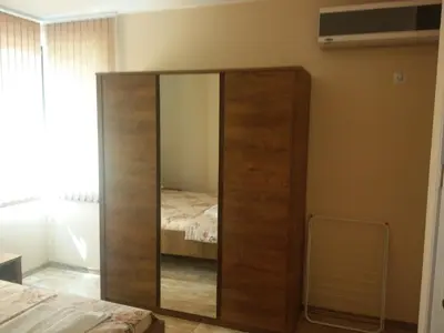 a large wooden cabinet in a bedroom with a bed at Apartment Batoevi Sozopol in Sozopol