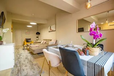 a living room with a table with purple flowers on it at City Center apartament “MARTA” in Varna City