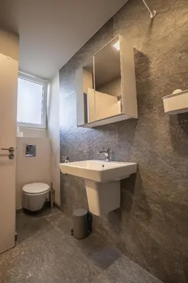 a bathroom with a sink and a toilet and a mirror at City Center apartament “MARTA” in Varna City