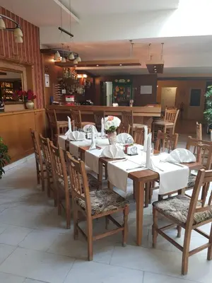 a dining room with a long table and chairs at Mirana Family Hotel in Burgas City
