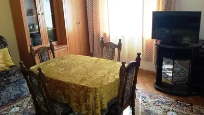 a dining room with a table and a television at Style Apartment in Pomorie