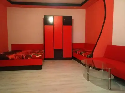 a room with two beds and a table and a chair at Studio Ekzarh in Varna City