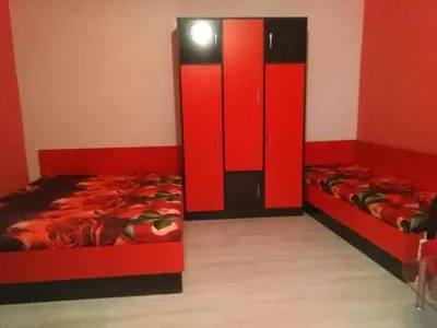 two beds in a room with red cabinets at Studio Ekzarh in Varna City