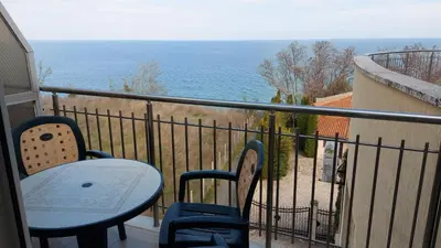 a balcony with a table and chairs and the ocean at Sunny House in Byala