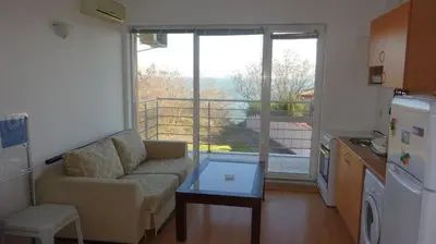 a small living room with a couch and a kitchen at Sunny House in Byala