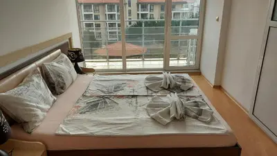a bed in a room with a large window at Sunny House in Byala