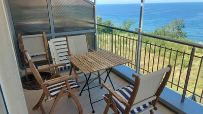 a balcony with two chairs and a wooden table and chairs at Sunny House in Byala