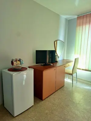 a room with a desk with a television and a refrigerator at Sozopol House Dimitrovi in Sozopol