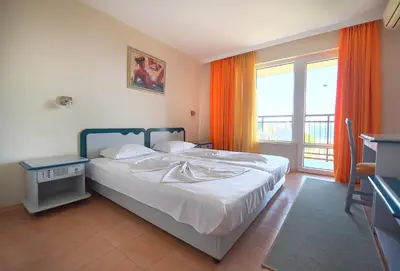 a bedroom with a bed and a large window at Hotel Iskar & Aquapark - All Inclusive in Sunny Beach