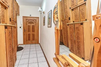 a hallway with wooden doors and a tile floor at Апартамент Бриз in Burgas City