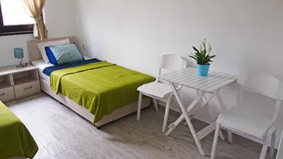 a small bedroom with a bed and a table at Villa Burkopolis in Sozopol