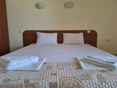 a bed with two towels sitting on top of it at Hotel Elica in Varna City