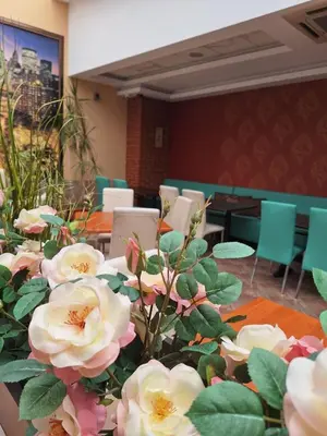 a room with tables with white flowers and chairs at Hotel Elica in Varna City