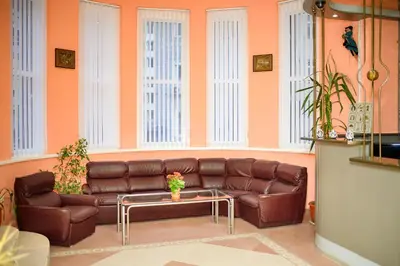 a living room with a brown couch and a table at Family Hotel Varna in Varna City