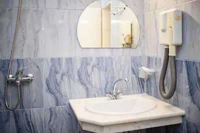 a bathroom with a sink and a phone on the wall at Family Hotel Varna in Varna City