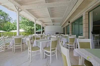 a dining room with white tables and chairs at Perla Plaza Hotel - All Inclusive in Primorsko