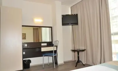 a hotel room with a desk and a mirror at Hotel Burgas Free University in Burgas City
