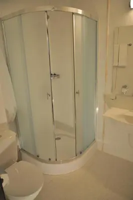 a bathroom with a shower with a toilet and a sink at Hotel Burgas Free University in Burgas City
