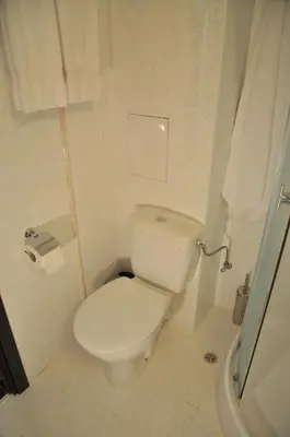 a white bathroom with a toilet and a shower at Hotel Burgas Free University in Burgas City
