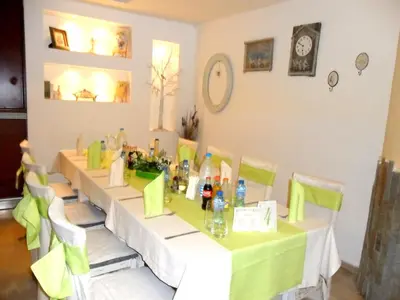 a table with a green table cloth and bottles of wine at Hotel Fors in Burgas City