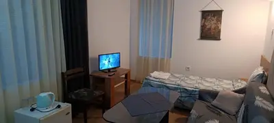 a living room with a couch and a television at Matev Hotel in Burgas City