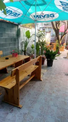 a wooden picnic table with an umbrella on a patio at Matev Hotel in Burgas City