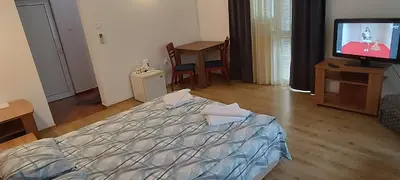 a bedroom with a bed and a tv in it at Matev Hotel in Burgas City