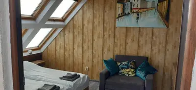 a attic room with a bed and a chair at Happy beach in Varna City