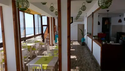 a restaurant with tables and chairs and a view of the ocean at Hemingway rooms in Happy Beach in Varna City