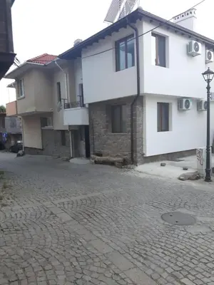 a white building on a cobblestone street at Guest House Antique in Sozopol