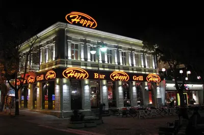 a building with a sign on top of it at night at Apartment Pier in Varna City