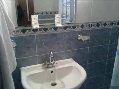 a bathroom with a white sink and a mirror at Apartment Pier in Varna City