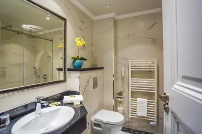 a bathroom with a sink and a toilet and a mirror at Hotel Residence Promenade in Burgas City
