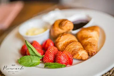 a plate of food with strawberries and croissants at Hotel Residence Promenade in Burgas City