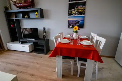 a dining room with a table with a red table cloth at Sky Garden Apartment Burgas in Burgas City
