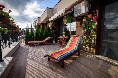 a patio with a colorful chair on a building at Sky Garden Apartment Burgas in Burgas City