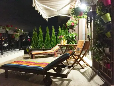 a patio with two chairs and a table on a balcony at Sky Garden Apartment Burgas in Burgas City