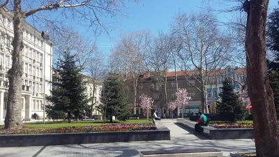 a park in front of a building with trees and flowers at Dreamcatcher's home by RV Apartments in Varna City