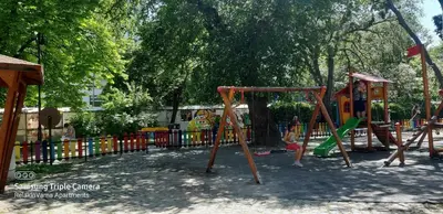 a playground in a park with children playing on swings at Dreamcatcher's home by RV Apartments in Varna City