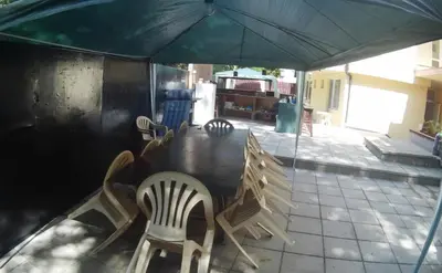 a table with chairs and an umbrella on a patio at Hotel Aia Kavatsi in Sozopol