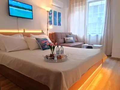 a bedroom with a large bed with a tv on the wall at Aglaya 2 in Pomorie