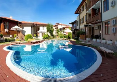 a large blue swimming pool in a courtyard with buildings at ДриймБг Апартаменти - Райска Градина, Свети Влас in Sveti Vlas