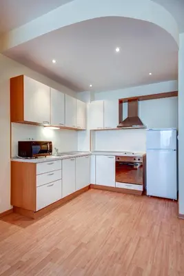 an empty kitchen with white cabinets and a refrigerator at ДриймБг Апартаменти - Райска Градина, Свети Влас in Sveti Vlas