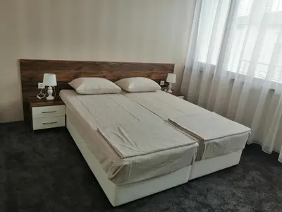a bedroom with a large bed with two night stands and two lamps at Джорджия in Kiten