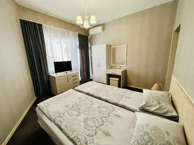 a hotel room with a bed and a television at Джорджия in Kiten