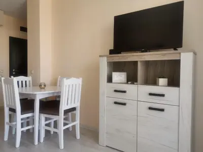 a white dresser with a tv on top of it at Aпартаменти Хоризонт in Sozopol