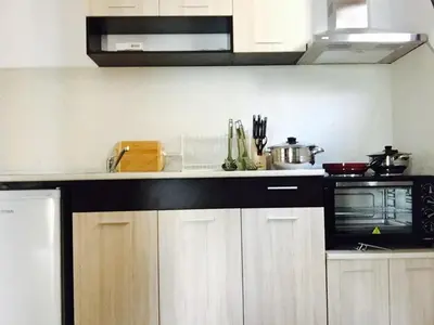 a kitchen with white cabinets and a black microwave at Dream View in Byala