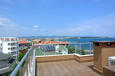 a balcony with a view of the water and buildings at Apartcomplex Golden Bay in Ravda